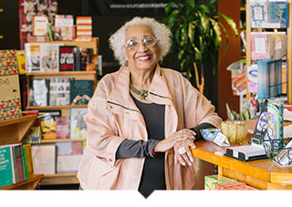 Older adult woman poses in bookstore