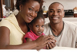 Mother and father with small child sitting on couch
