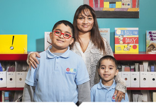 Mother poses with her two children inside of Equitas Academy Charter School classroom