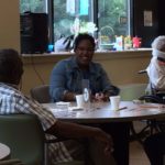 Woman and man sitting at table with bingo cards.