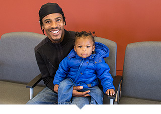 Father and daughter sitting in Unity Health Care lobby waiting for doctor in Washington DC