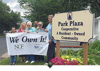 Group of cooperative homeowners hold We Own It sign