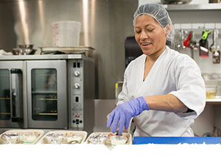 Female chef preps food in kitchen