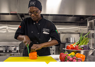 Female chef prepares food in professional kitchen