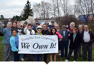 Homeowners pose with We Own It Banner