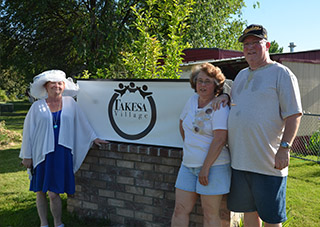 Residents pose with Takesa Village sign