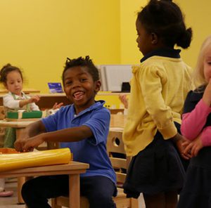 Elementary school student sits at desk working on art project