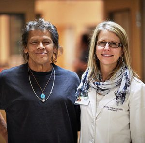 Female doctor poses with older female patient.