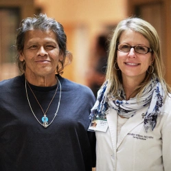 Female doctor poses with older female patient.