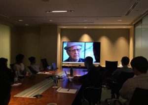 Group of staff members watch a television show.