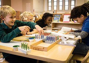 Group of charter elementary schools students of different races work together at table