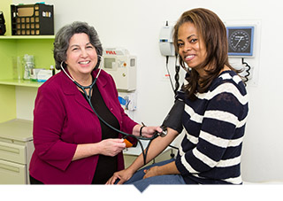 Doctor checking blood pressure of patient at Unity Health Care facility