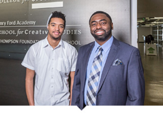 Henry Ford Acadamy charter school graduate Devon Yancy stands in front of school sign with principal