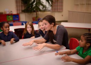 A teacher sings with students.