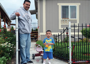 Father and son play in front of their house.