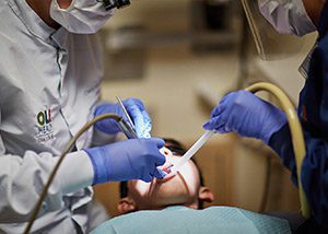 A dentist cleans a boys teeth.