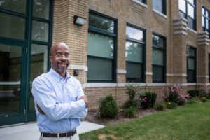 Man stands in front of housing complex