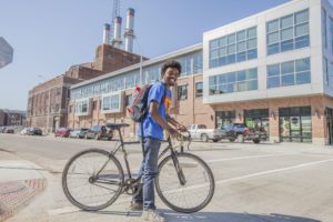 Young man on a bike in front of a building