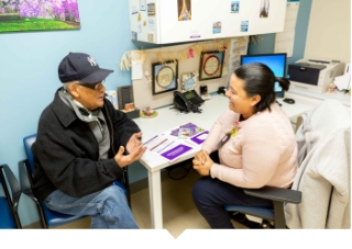 Older adult male speaks with pharmacist