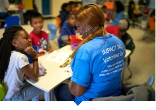 Capital Impact employee reads to children during volunteer day.