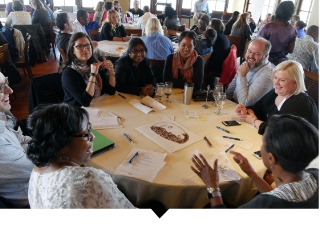 Group of Capital Impact employees participate in diversity, equity, and inclusion discussion at large table.