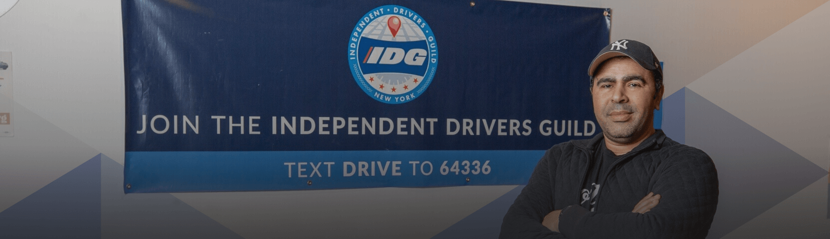 Independent Drivers Guild Driver stands in front of banner
