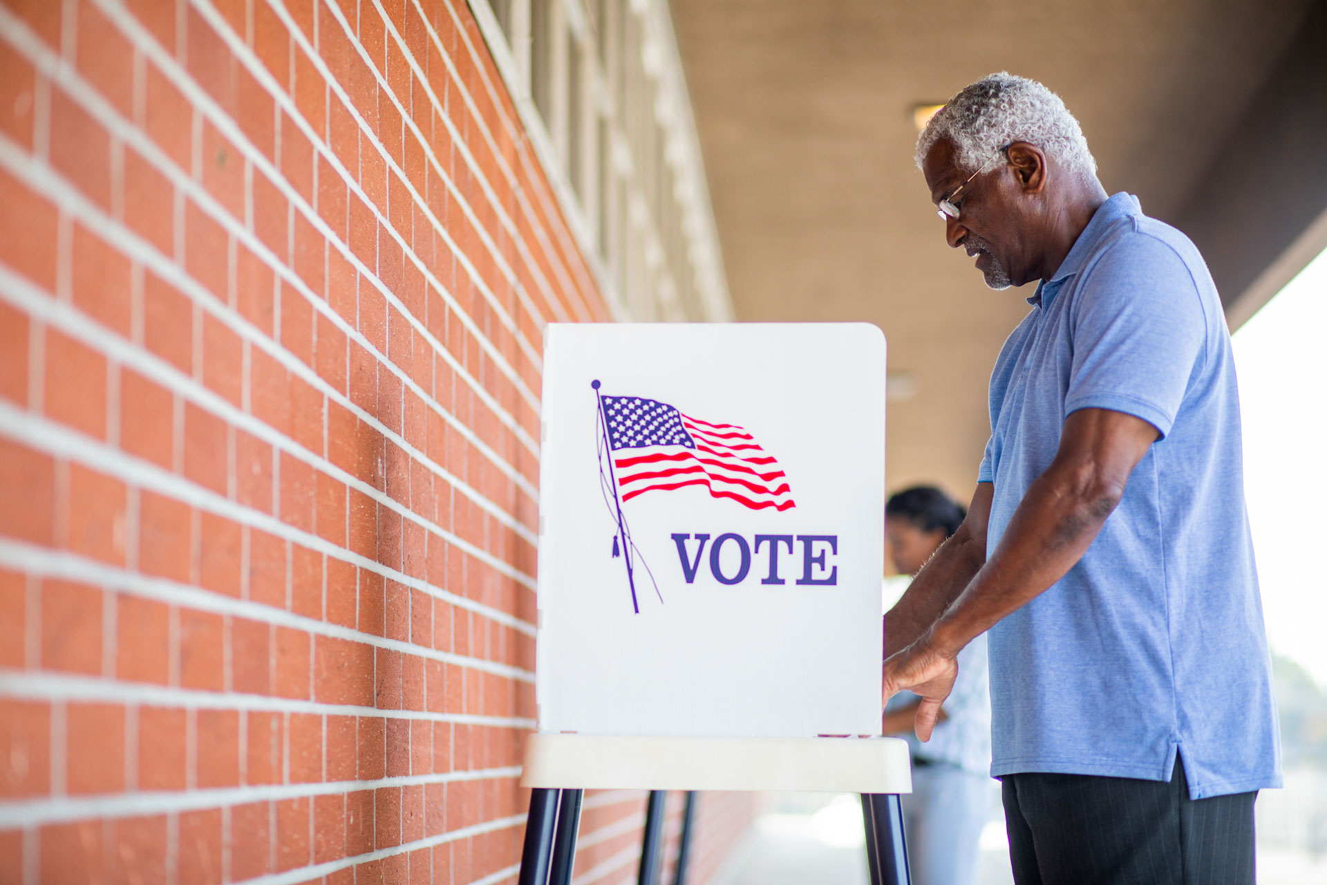 A senior black man casts his ballot on election day.