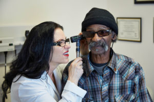 Older Black man getting health care from female doctor