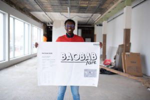 Man stands in new store with blueprints