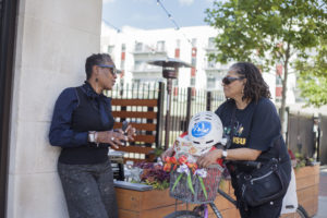 Two women chat in front of their apartment building in Detroit