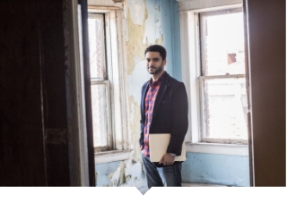 Equitable Development Initiative graduate poses inside of housing property.