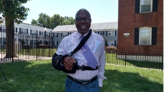 Worthing Woods resident poses for a photo outside of an affordable housing complex.