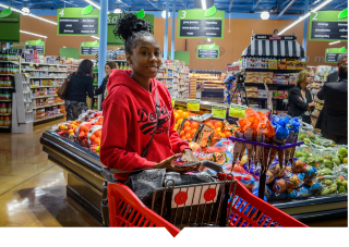 Young female shopper browses the produce section at Imperial Fresh Market