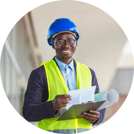GHD graduate wears hard hat at a construction site.