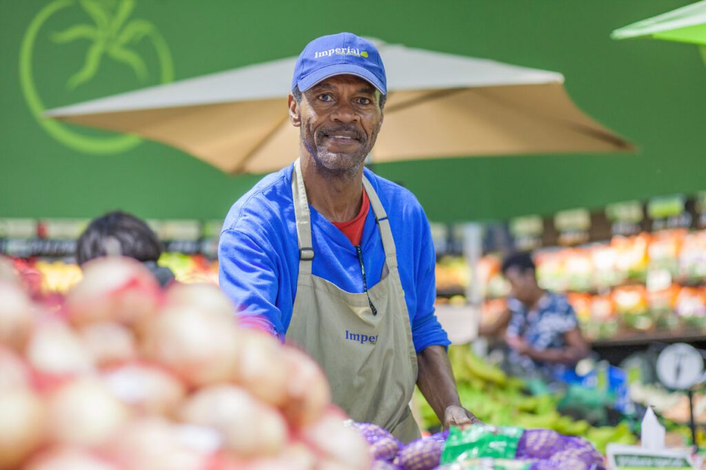 Grocery store employee stocks produce