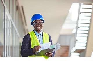 Developer wearing a hard hat stands on a construction site