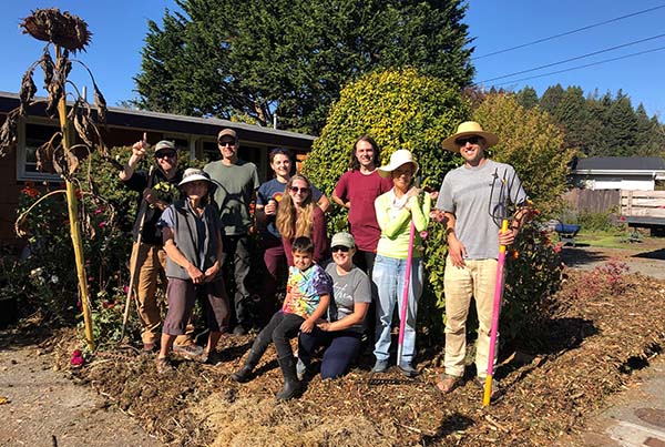 People stand among plants, smiling