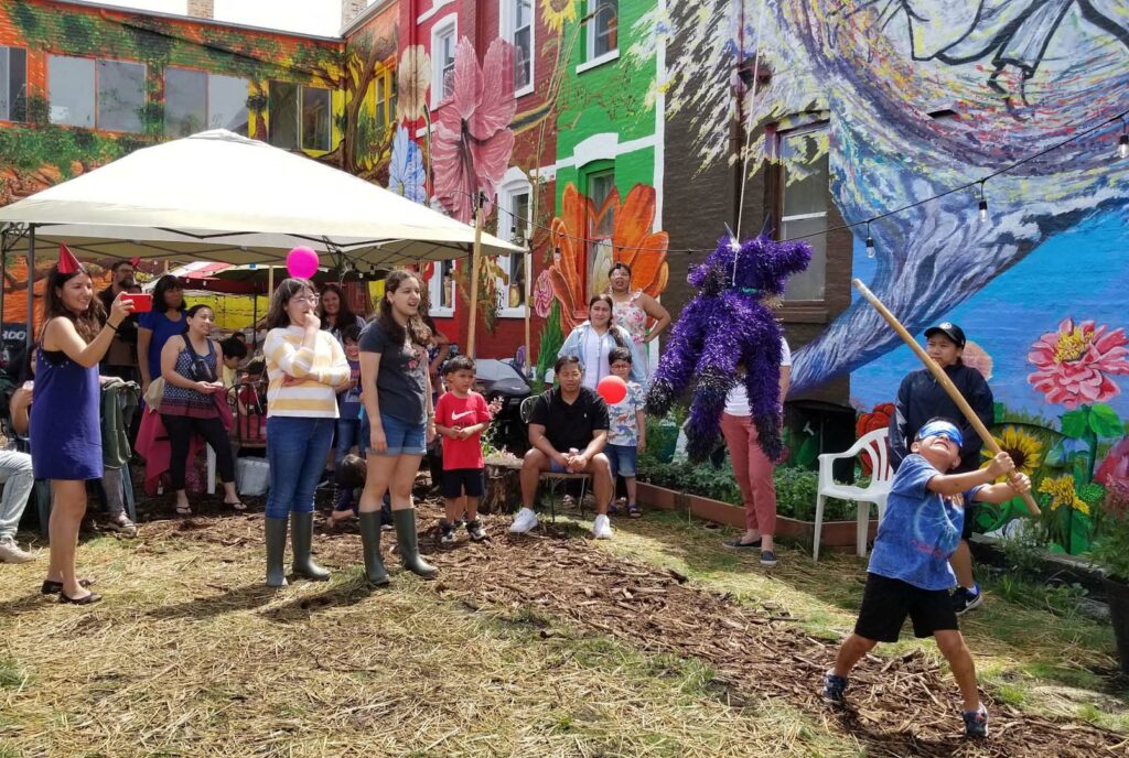 Boy swings at pinata while family watches