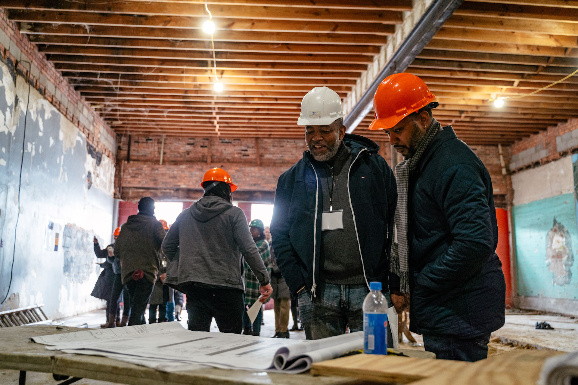Black real estate developers work in hard hats on construction site