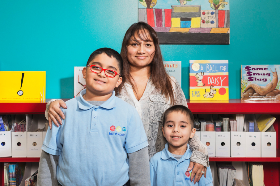 A mother poses with her two sons in a school library.