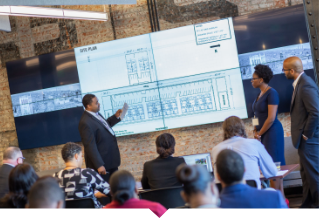 A group of community-rooted real estate developers gather to review building plans.