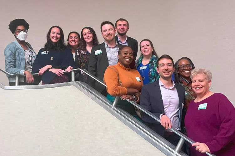 Members of the Community Purchasing Alliance Cooperative, one of Capital Impact Partner's Co-op Innovation 2024 Award winners, pose together on a set of stairs.