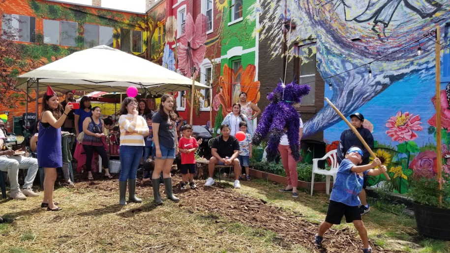 A lively group surrounds a bright mural, showcasing unity, belonging, and the importance of affordable housing cooperatives.