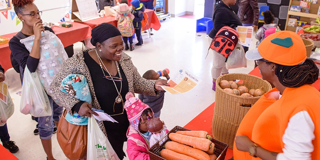 Families line up to receive healthy food distributions at Martha's Table Joyful Food Market