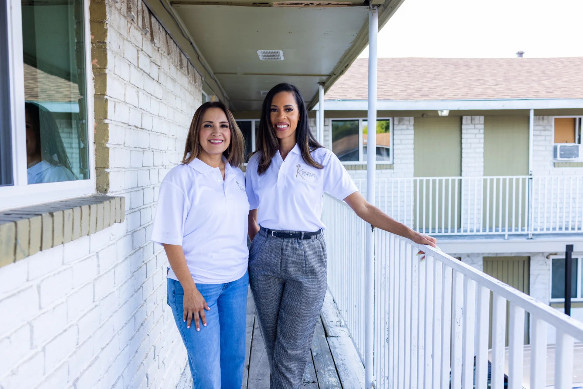 A real estate developer and a resident smile in front of Kingdom South Apartments, an affordable housing development that was revitalized thanks to financing from Capital Impact Partners.