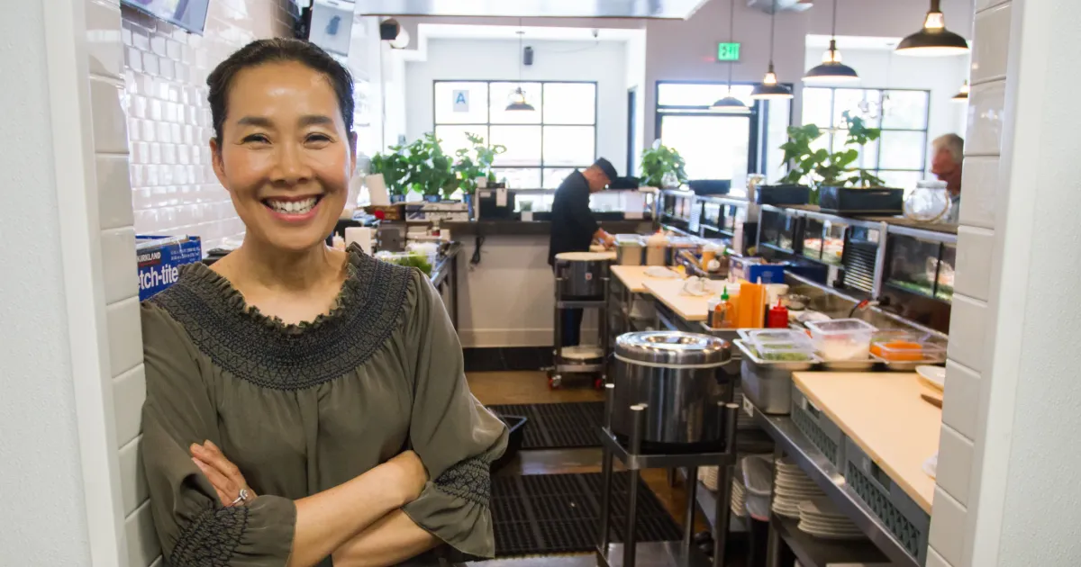 A small business owner stands inside the kitchen of her business, Mikko sushi, a restaurant that received financing from Momentus Capital.