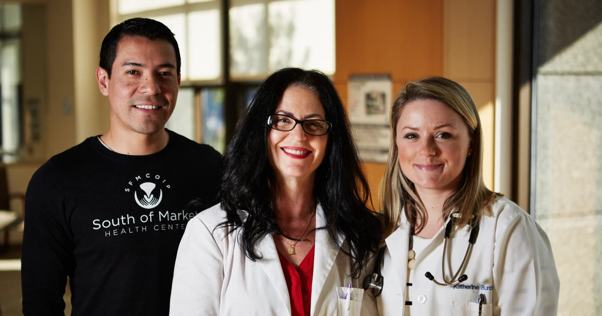 David Reynoso, Judy Anderson and Katherine Burchell pose together inside of the South of Market Health Center. The building of the center was made possible with lending from Capital Impact Partners.