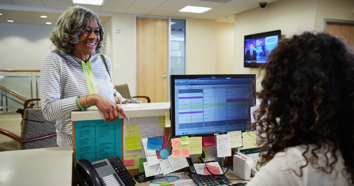 A patient checks into the reception desk at South of Market Health Center.