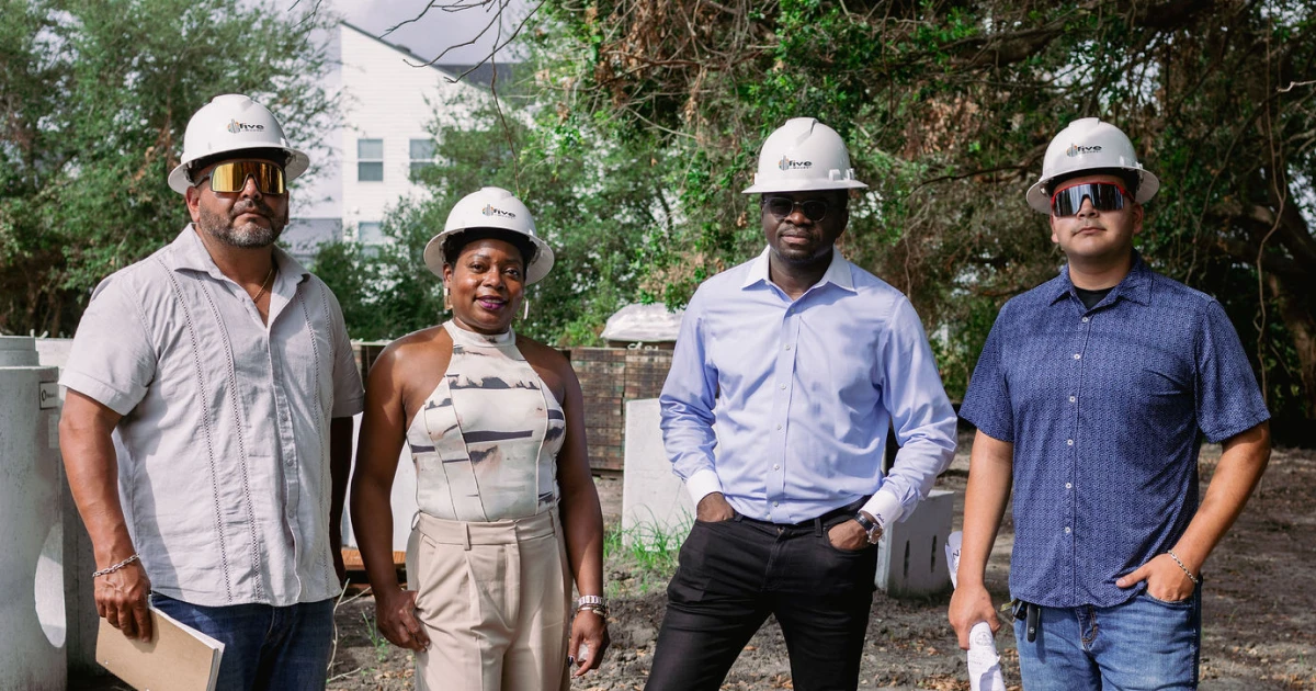 Four developers on-site at a Houston affordable housing project supported by Momentus Capital, surrounded by early-stage infrastructure.